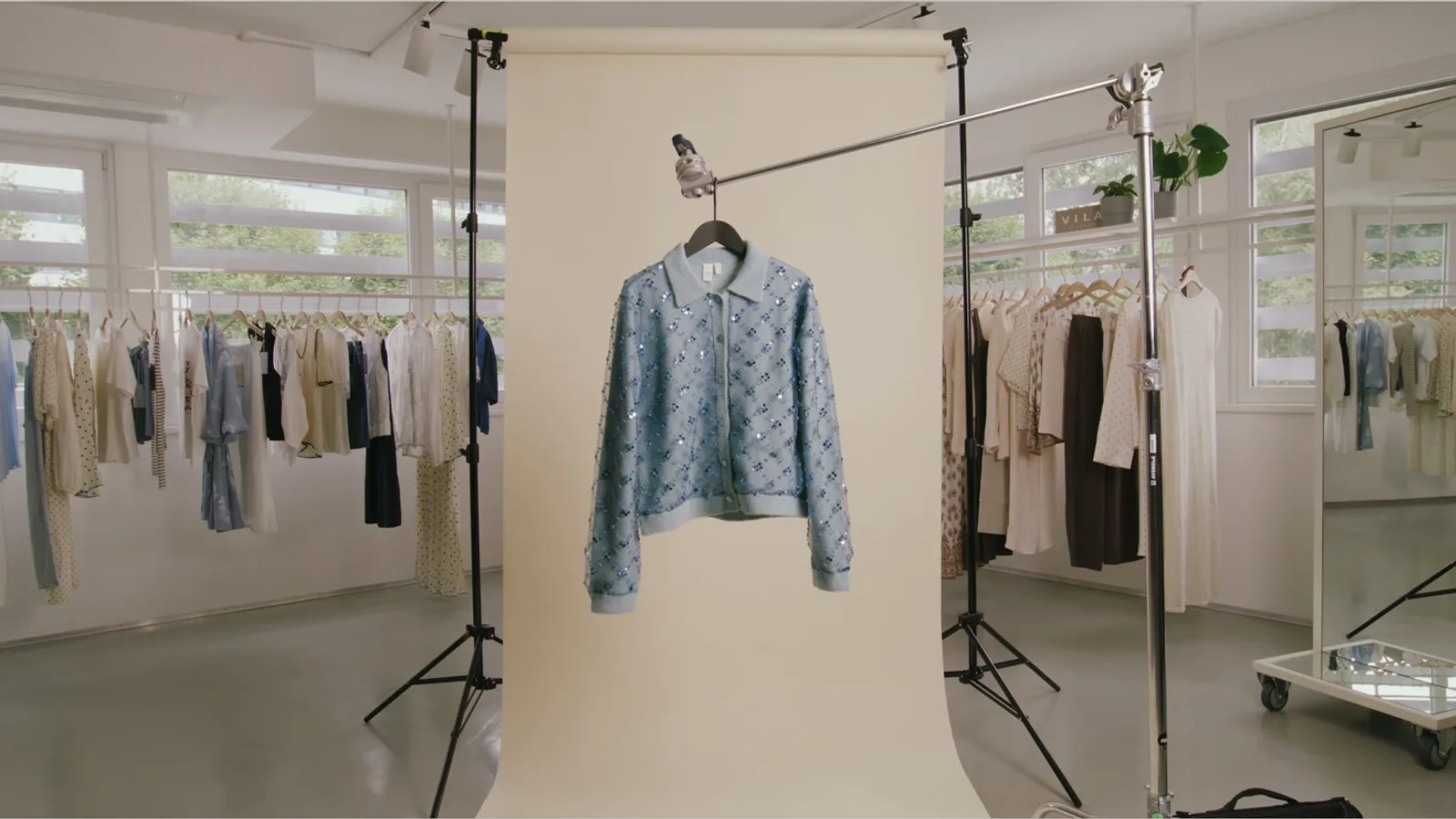 Strickjacke an einem C-Stand vor schmalem Hintergrund im Showroom von BESTSELLER