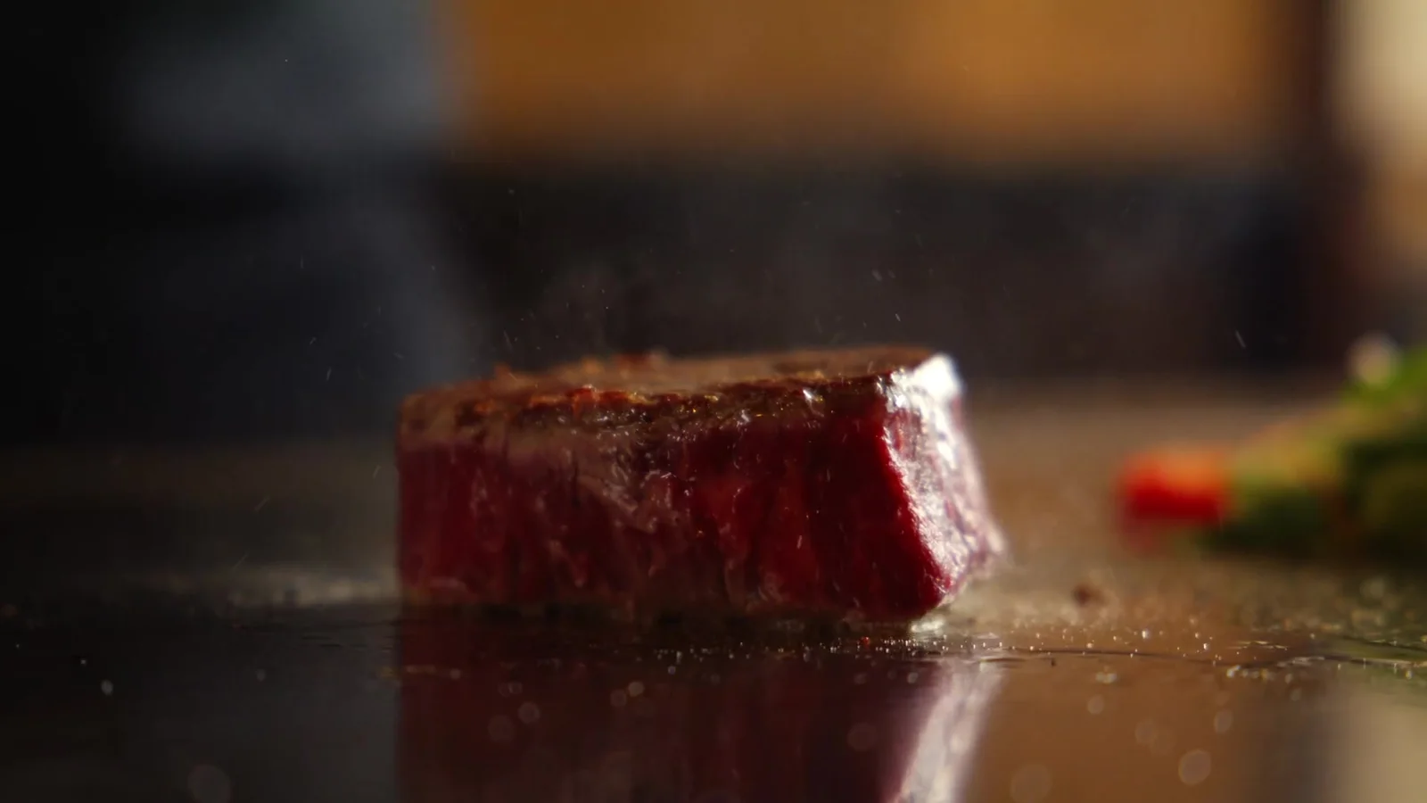 Ein Stück Fleisch auf der heißen Platte, Dampf steigt auf